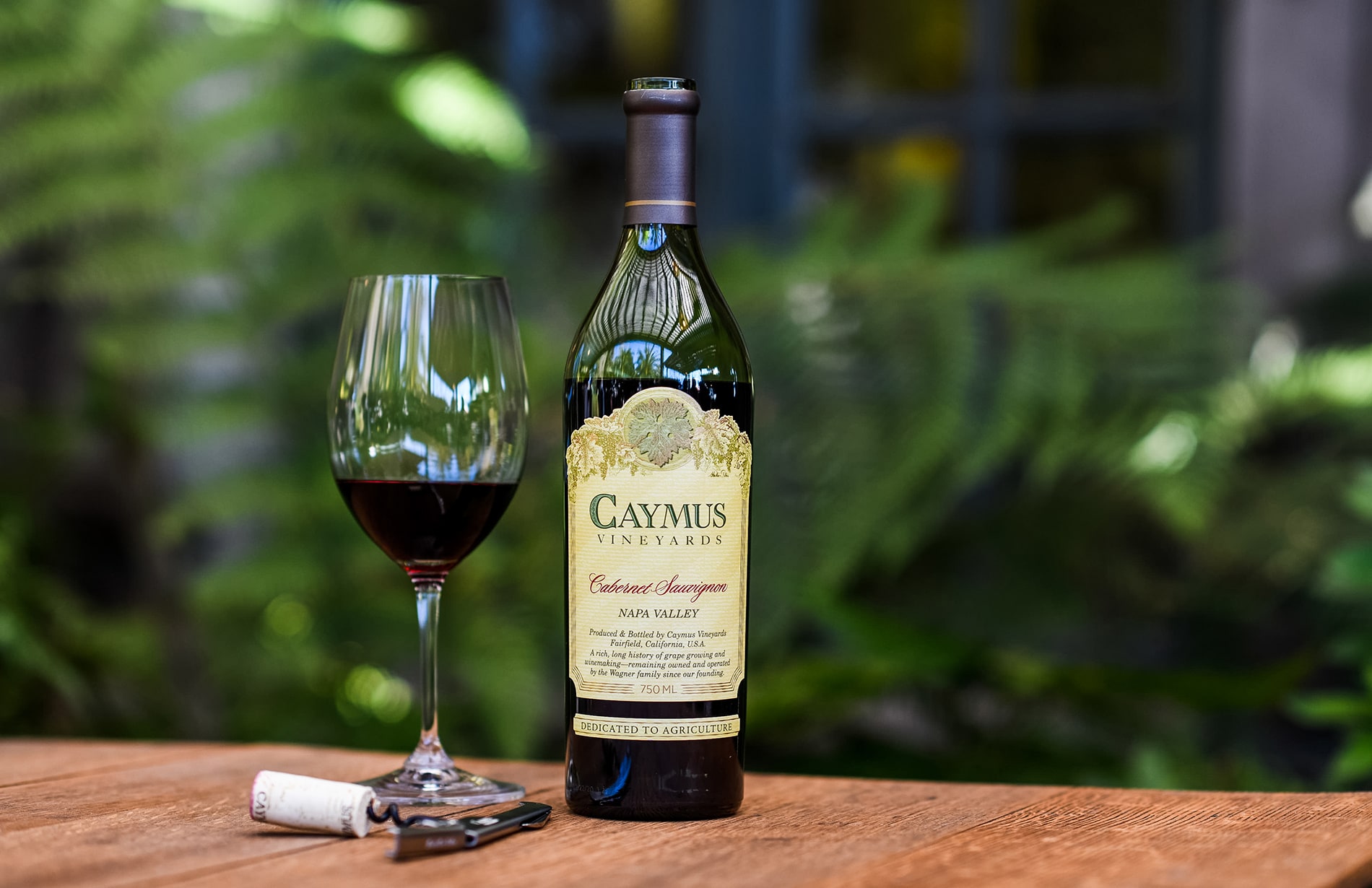 Bottle of Caymus Cabernet Sauvignon beside glass of wine